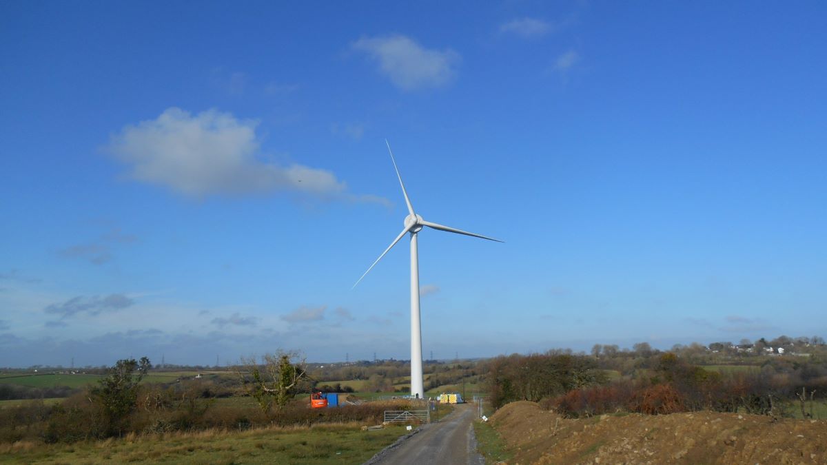 A wind turbine in Wales against a blue sky with a few clouds