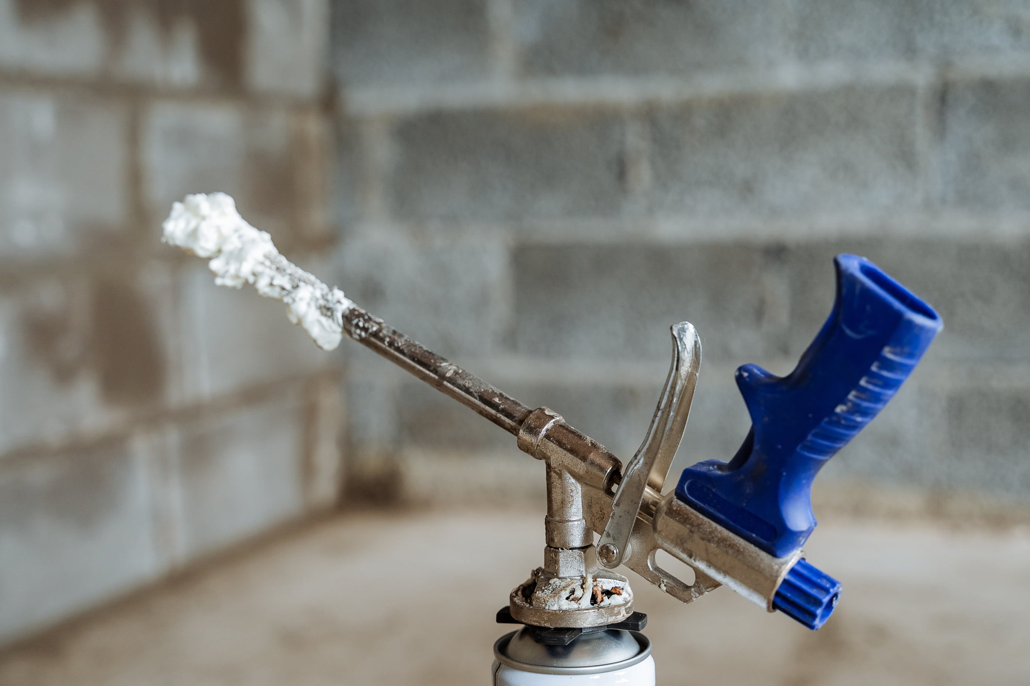 A spray foam gun with some foam on the nozzle.